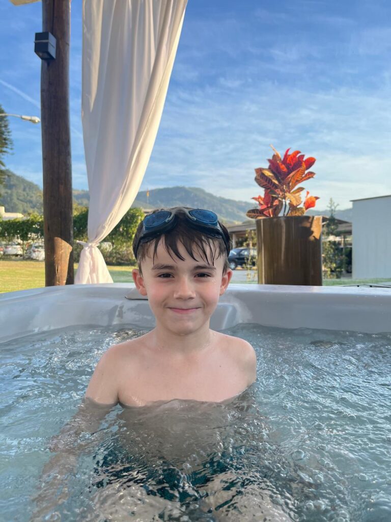 menino dentro de jacuzzi com vista no fundo