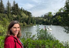 mulher sorrindo em frente a lago de parque verde ao redor