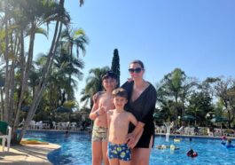 mulher com dois filhos e piscina ao fundo