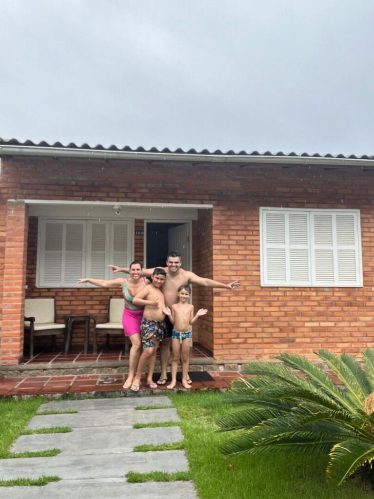 família em frente a casa de tijolos