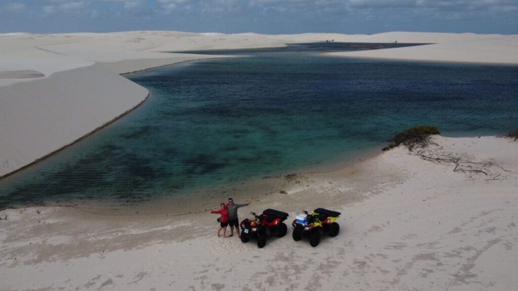 casal com quadriciclos a beira de grande lagoa em vista aérea
