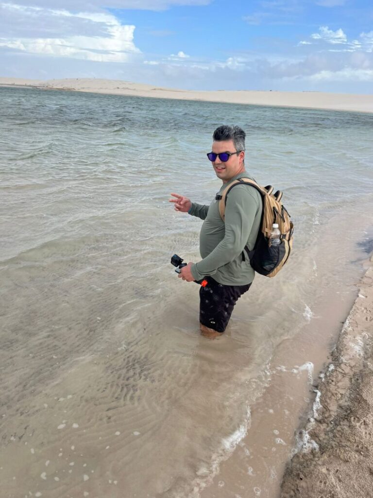 homem um pouco afundado em areia de lagoa.