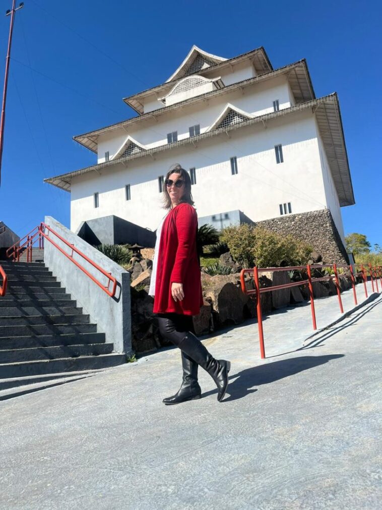 mulher em frente a castelo japones