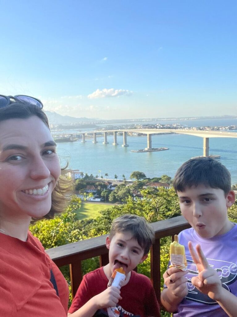 mãe e dois meninos em um mirante para o mar