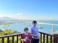 dois meninos em mirante com vista de ponte de mar