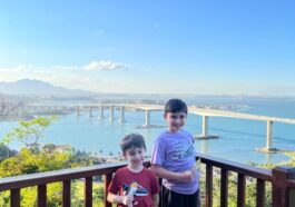 dois meninos em mirante com vista de ponte de mar