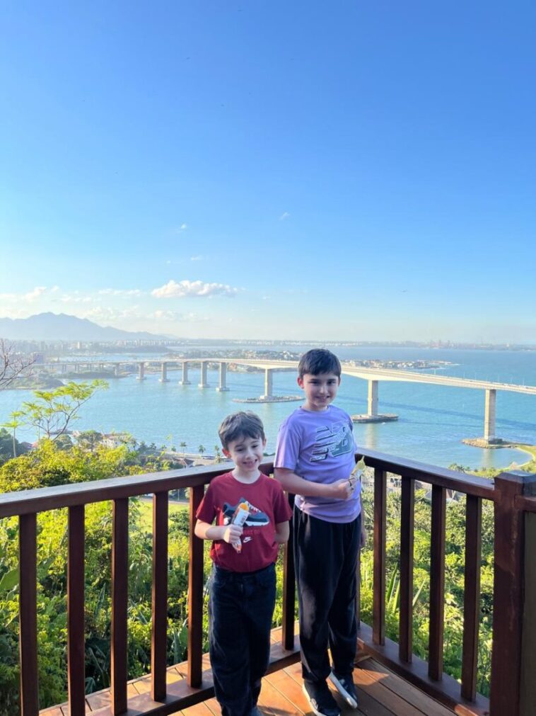 dois meninos em mirante com vista de ponte de mar