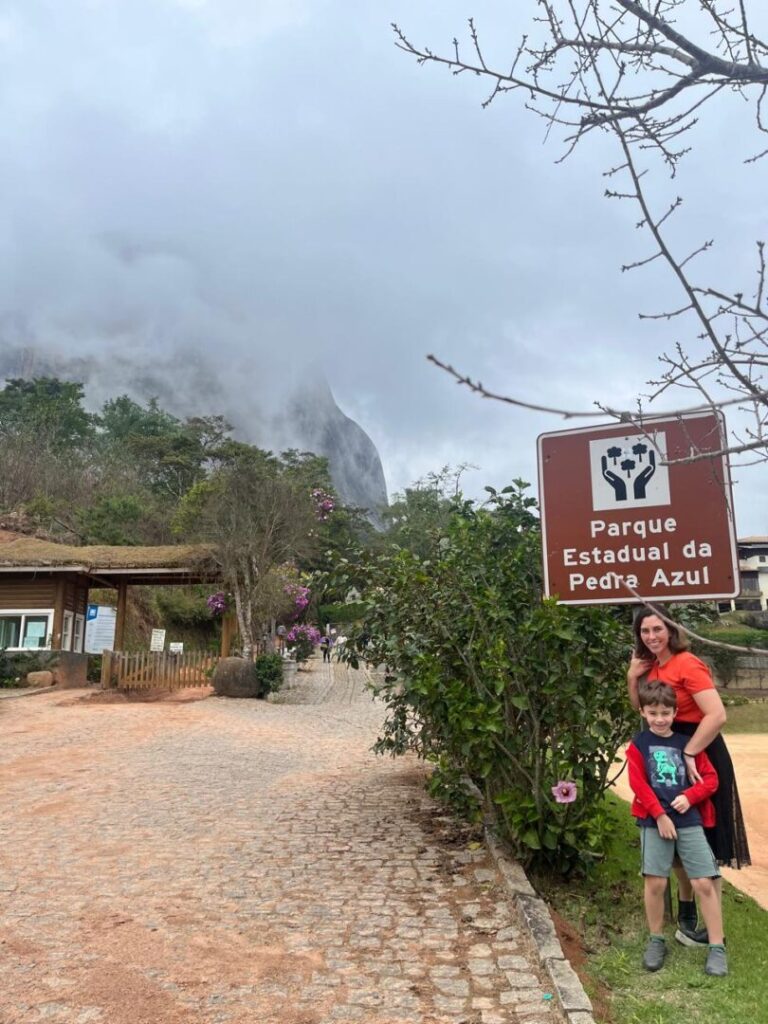 mãe e filho em frente a placa de região serrana