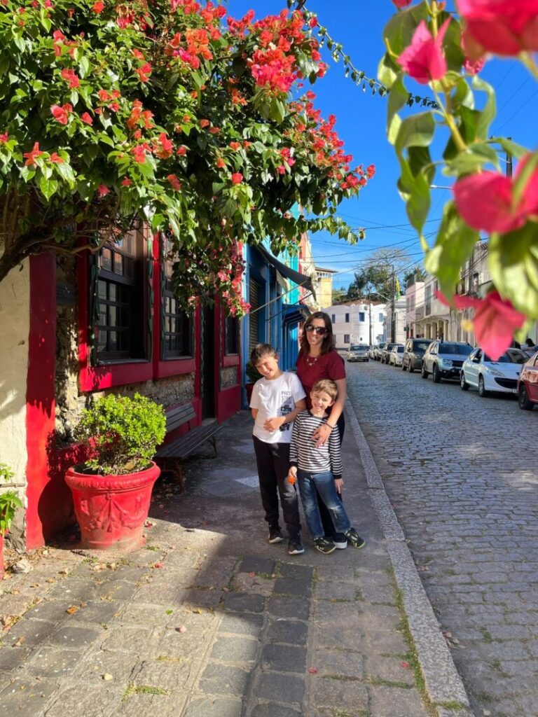 mãe e dois meninos e centro histórico com árvore florida