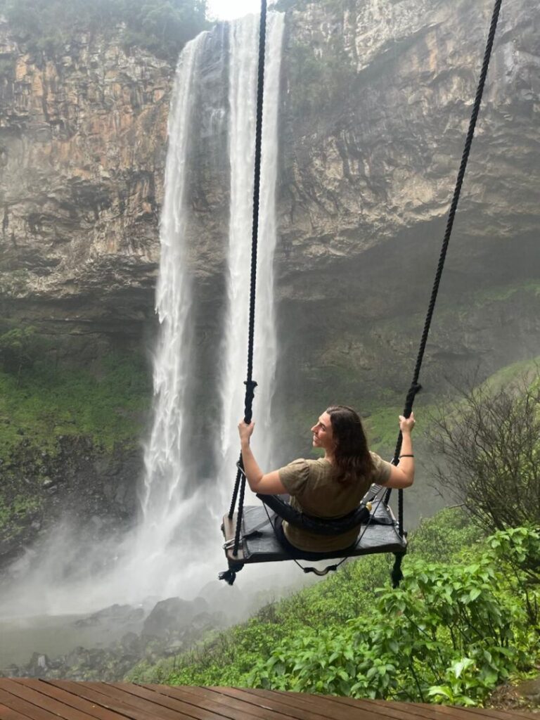 mulher em balanço com cascata ao fundo