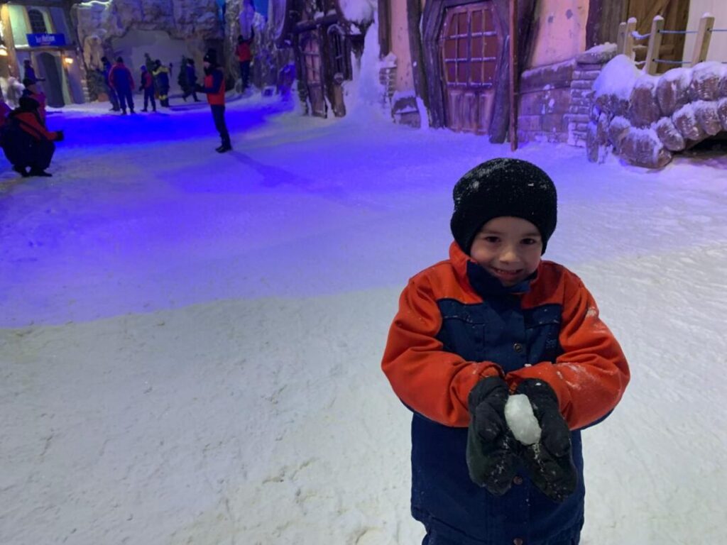 menino em espaço temático de neve