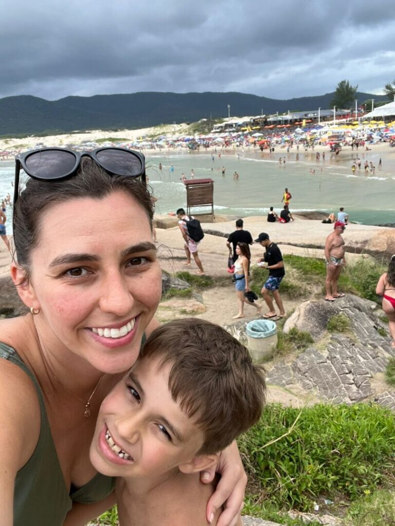 selfie mãe e filho pequeno em praia no fundo.