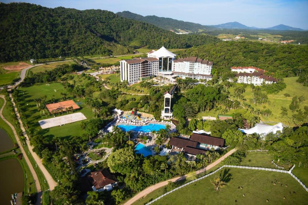 Imagem aérea de resort em volta de área verde e montanhas