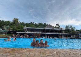 familia de pai, mãe e dois meninos dentro de grande piscina de parque aquático