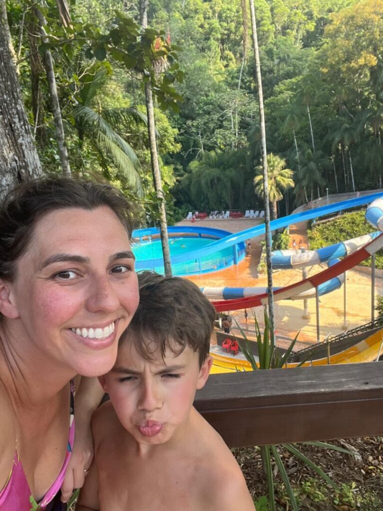 mãe e filho com tobogãs ao fundo