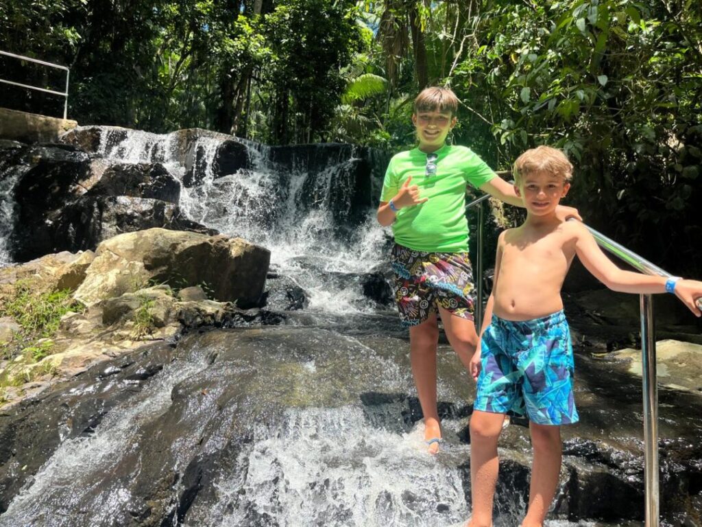 dois meninos em frente a cachoeira