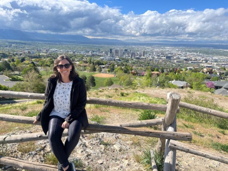 mulher sentada com vista ao fundo do alto de cidade