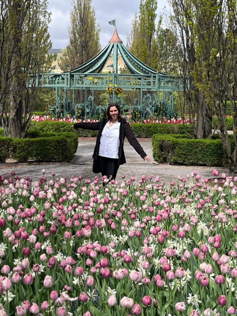 Mulher no meio de grande jardim de tulipas