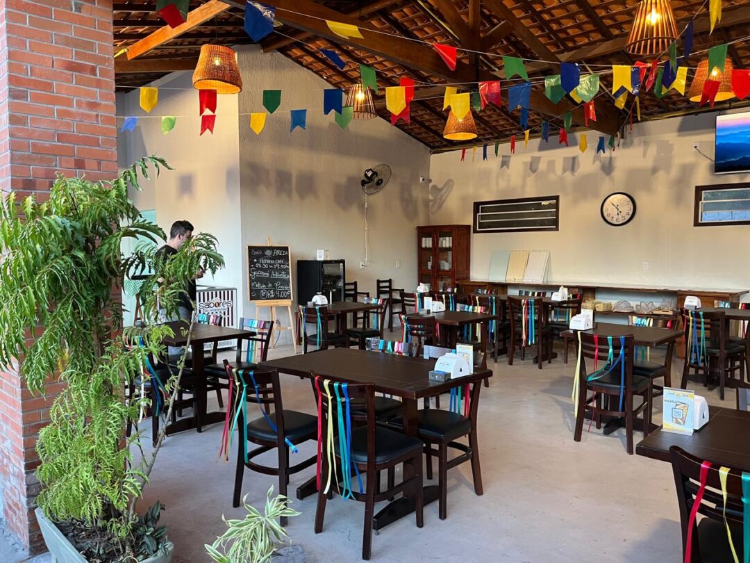 salão com mesas e cadeiras de restaurante de pousada com decoração junina