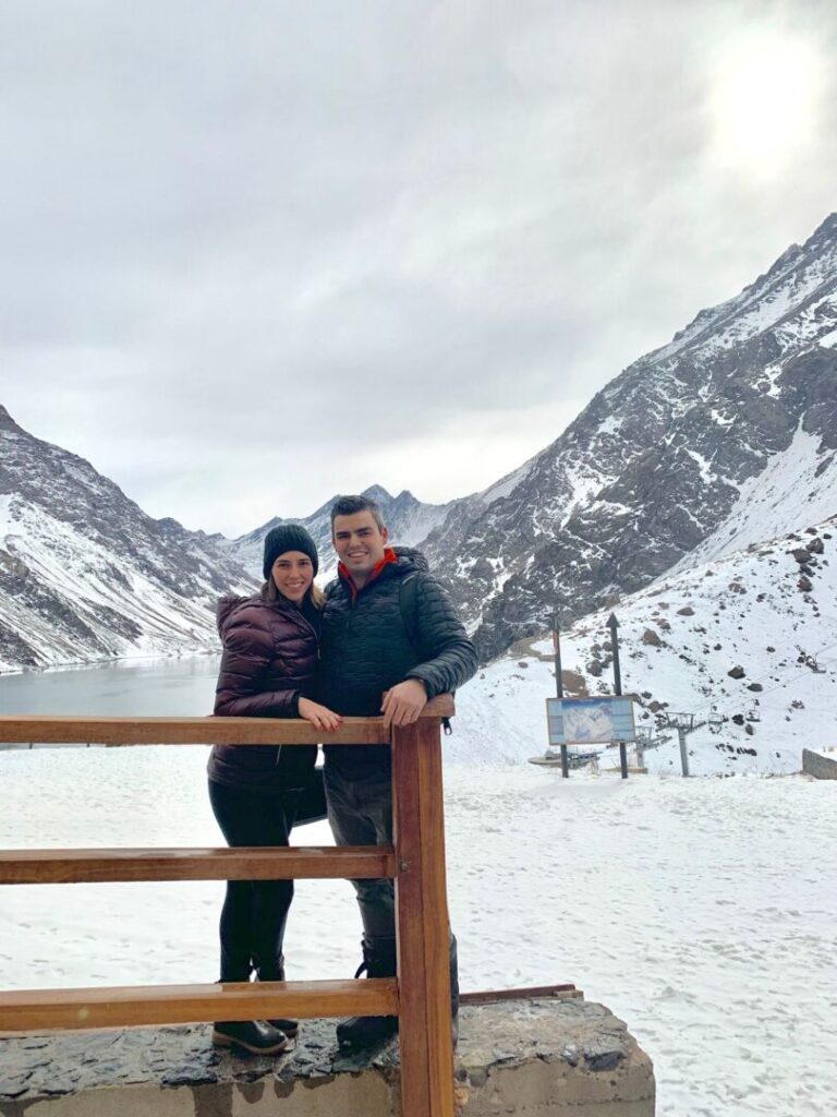 casal em frente a montanha com lago