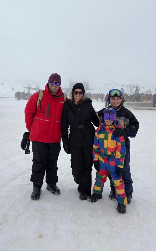 familia de mae, pai e 2 meninos em visual de neve