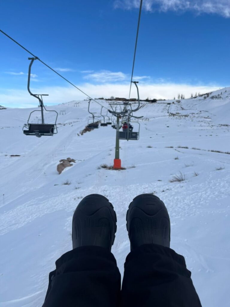 pés do alto de um teleférico com neve