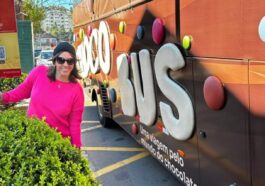 mulher ao lado de ônibus temático de chocolate