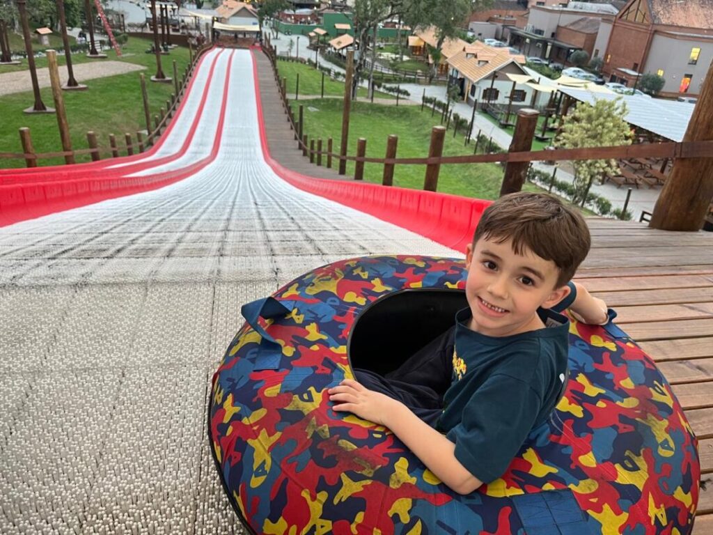 menino sentado em boia com grande pista em rampa a frente