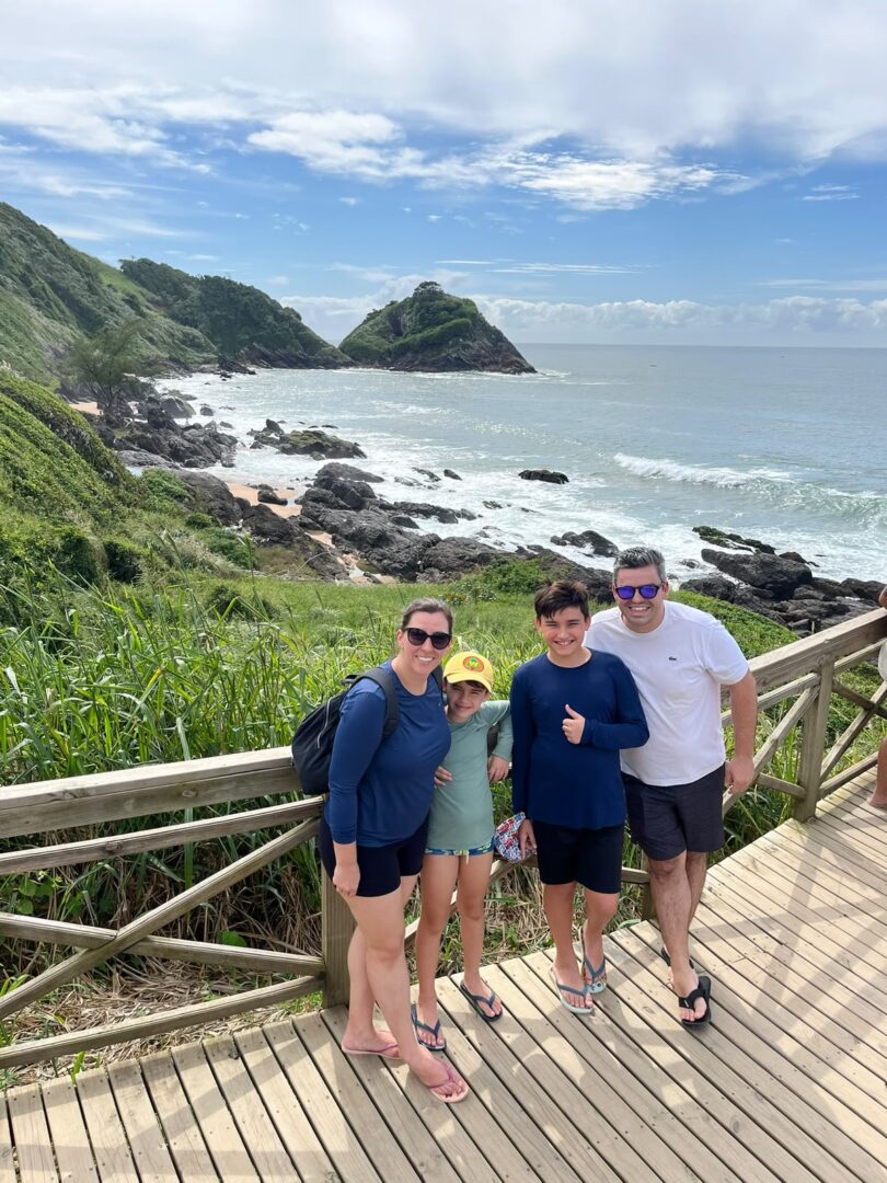 familia em mirante com vista para mar e pedras