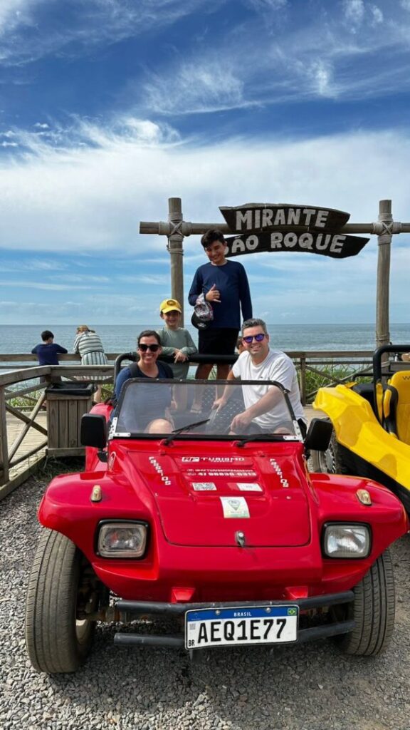 familia sentada em buggy com praia ao fundo