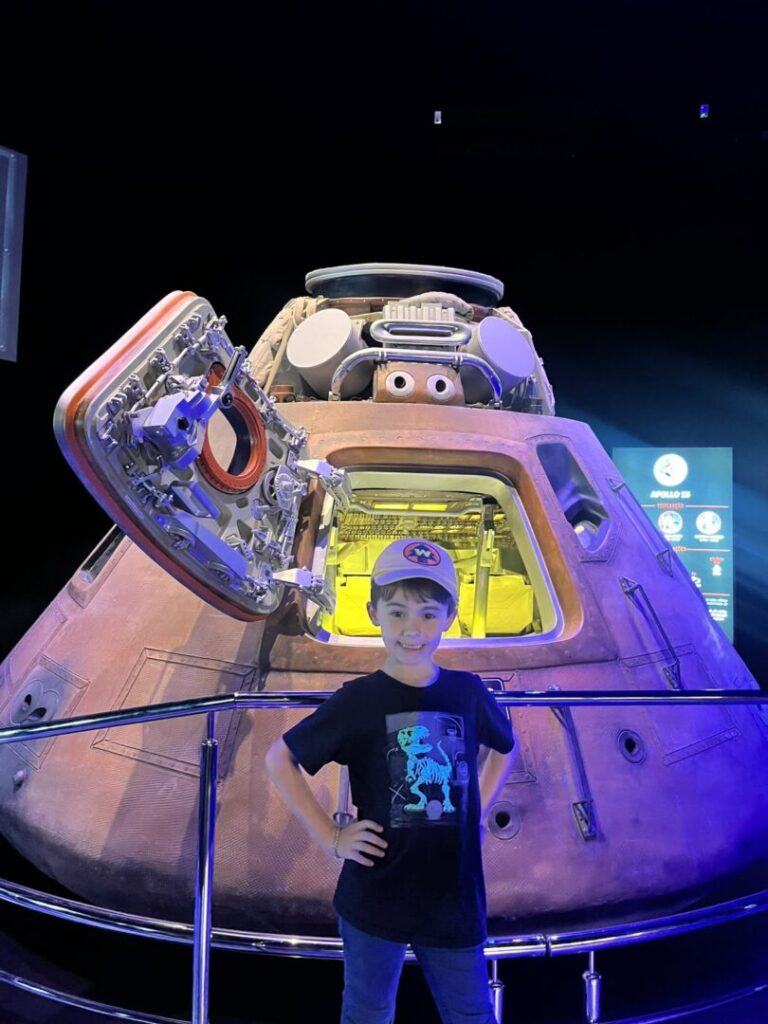menino em frente a módulo espacial
