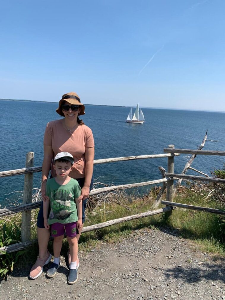 mulher com menino em mirante com vista para o mar