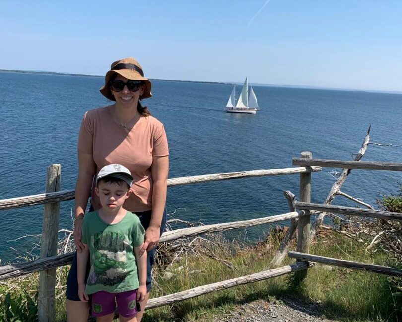 mulher com menino em mirante com vista para o mar