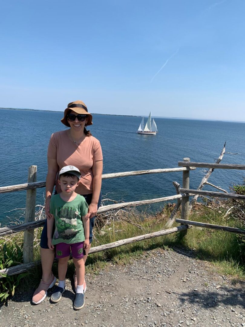 mulher com menino em mirante com vista para o mar