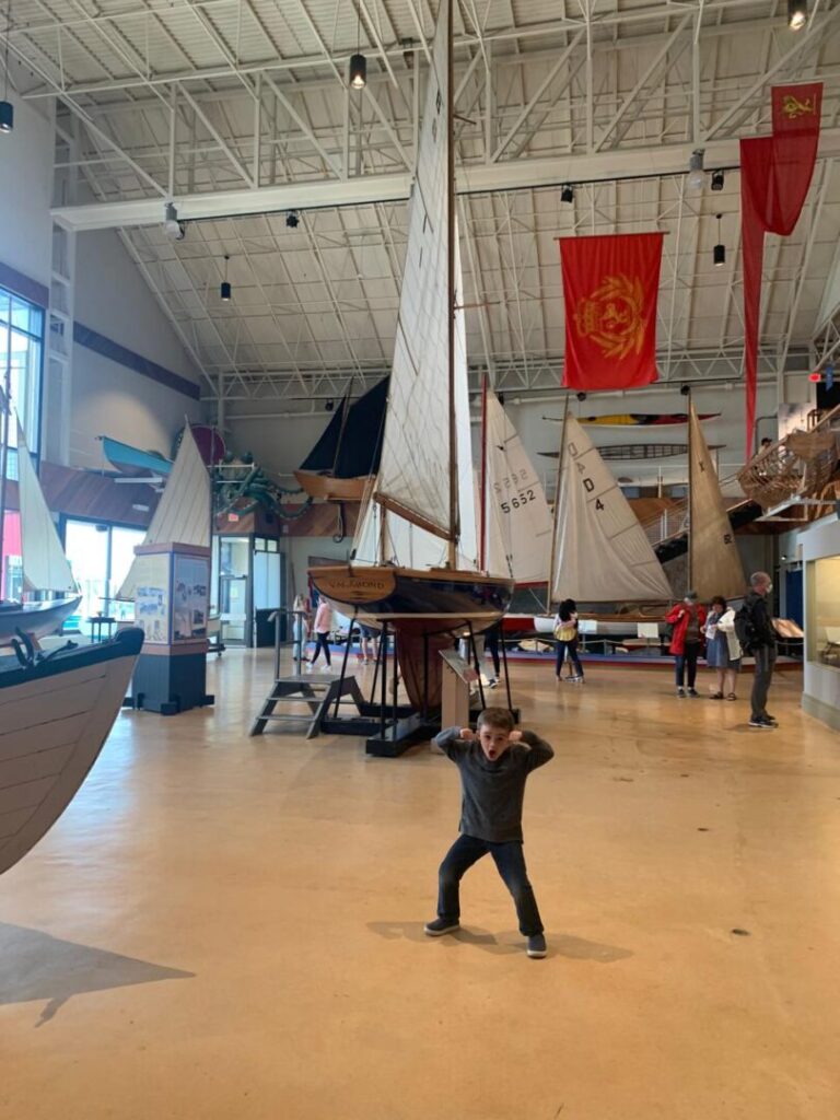 menino em frente a grande barco em museu