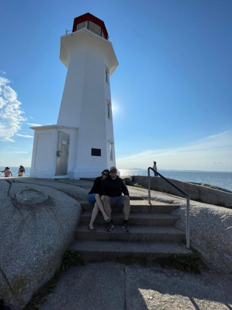 casal em escadaria com farol ao fundo